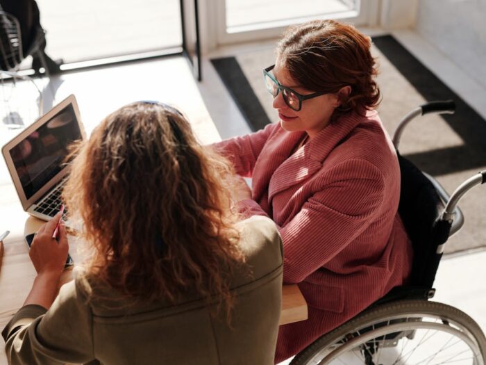 Photo by Marcus Aurelius: https://www.pexels.com/photo/woman-in-red-sweater-wearing-black-framed-eyeglasses-sitting-on-wheelchair-4063789/